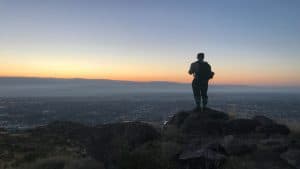 Middle-aged man overlooking the city at sunrise, reflecting on spiritual health in midlife.
